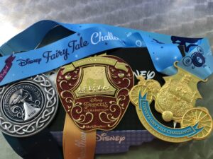 Photo of Disney Enchanted 10K medal, Disney Princess Half Marathon medal, and Fairy Tale Challenge Medal 